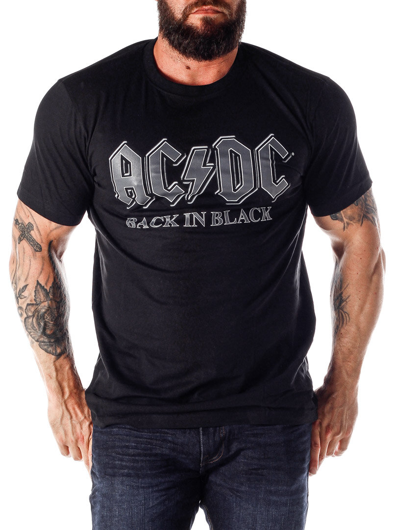 mann som står i et studio iført en svart ac dc T-skjorte